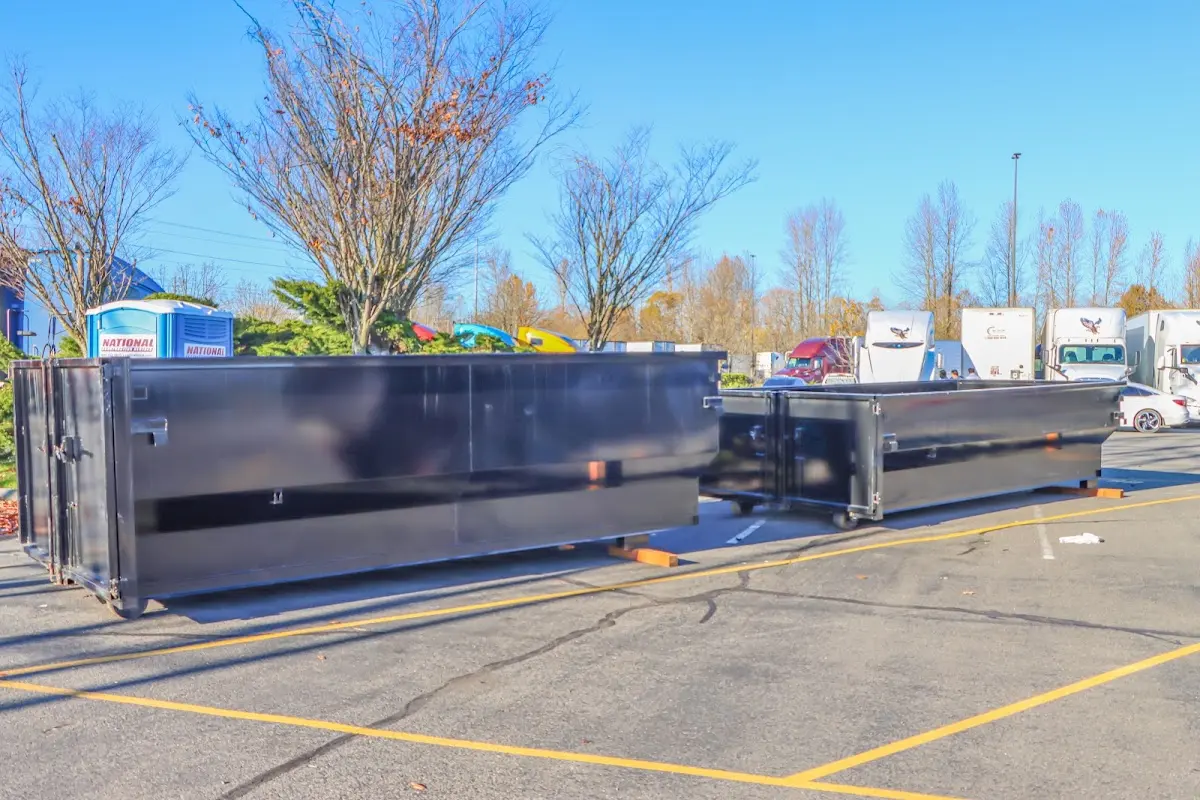 Professional dumpster rental service with roll-off container on residential driveway in Paragould